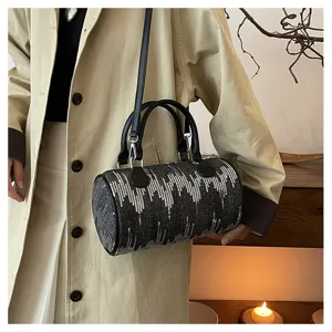Close-up detail view of the dark grey cylindrical handbag showcasing stylish sequin wave patterns.