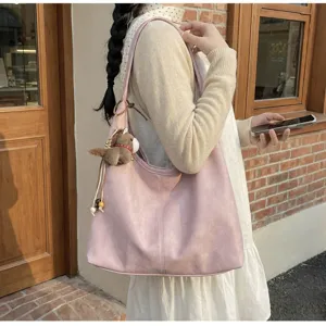 Vue detaillee du grand sac cabas epaule rose avec joli pendentif cheval en peluche en exterieur.