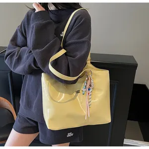 Yellow glossy tote bag detail view, showing large capacity and stylish shoulder strap design.