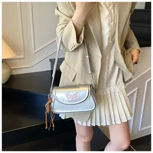 Vue détaillée du sac porté épaule argenté tendance avec joli motif papillon rose vif.
