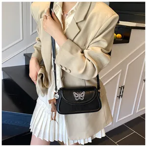 Élégant sac bandoulière noir pour femme avec motif de papillon blanc pour usage quotidien.