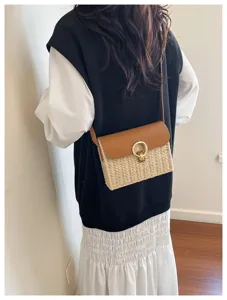 Detail view of a retro straw shoulder bag with brown leather flap and stylish metal ring clasp.