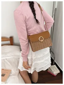 Retro straw woven crossbody bag detail showing leather flap and golden lock design.