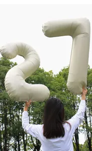 Milky white large number foil balloons outdoor photography scene, party decoration detail.