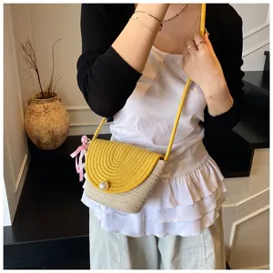 Handmade woven mini crossbody phone bag detail, stylish yellow and beige shoulder bag.
