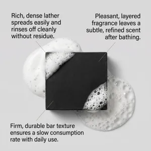 Vue détaillée d'un savon noir nettoyant avec une mousse blanche riche et une texture lisse.