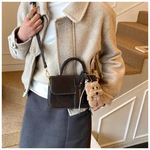 Retro matte shoulder bag for women, stylish crossbody and handbag with plush puppy charm detail.