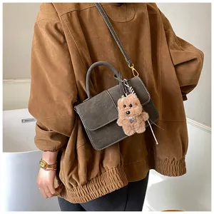 Retro frosted leather crossbody bag with cute bear pendant, stylish women handbag detail.