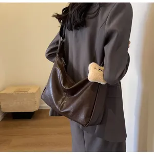 Retro brown slouchy shoulder bag detail view, soft leather dumpling bag showcase style.
