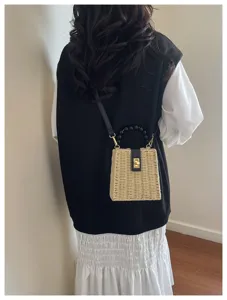 Retro straw woven crossbody bag with beaded handle, stylish lock closure, perfect for beach.