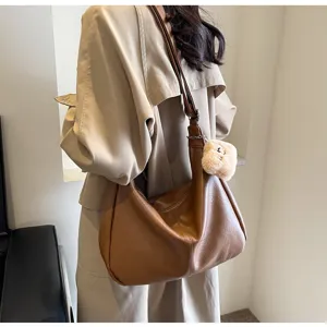 Detailed view of the brown leather hobo shoulder bag worn on model, showing soft slouchy style.