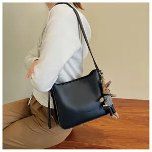 Zwarte leren schoudertas met schattige konijnenhanger, casual crossbody tas voor dames.