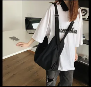 Gedetailleerd overzicht van zwarte canvas schoudertas, casual tote met brede riem voor dagelijks.