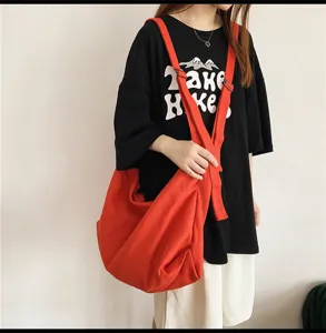 Gedetailleerd overzicht van de grote oranje canvas schoudertas in trendy casual stijl.