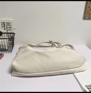 Gedetailleerd overzicht witte canvas schoudertas, eenvoudig ontwerp voor dagelijks gebruik.