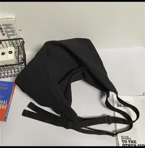 Gedetailleerd overzicht van zwarte canvas schoudertas, casual shopper voor dames.