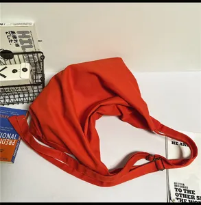 Detail van de oranje canvas tas met zachte textuur en verstelbare schouderriem voor dagelijks.