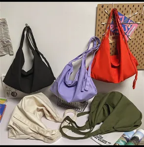 Gedetailleerd overzicht van canvas schoudertas, casual slouchy design, dagelijkse stijl, meerdere kleuren.