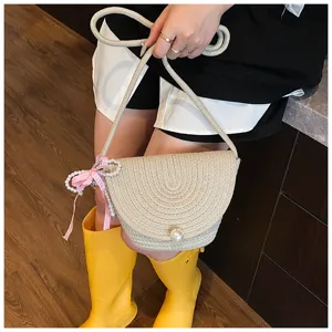 Handmade woven straw mini shoulder crossbody bag with elegant pearl decoration and ribbon.
