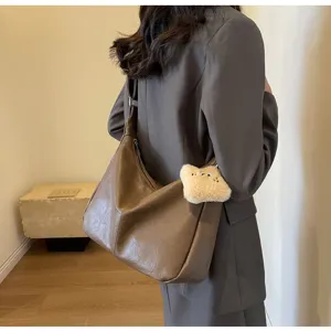 Women's vintage brown leather shoulder crossbody hobo bag with cute plush bear pendant.