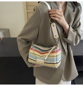 Vista dettagliata della borsa a spalla in paglia a righe colorate da donna con catena e tracolla.
