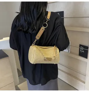 Borsa a tracolla estiva in paglia intrecciata con catena, dettaglio borsa cilindrica chic.
