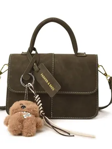 Dark green matte leather handbag with furry bear keychain, stylish crossbody bag for women.