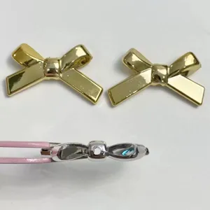 Gold and silver bow shaped UV plated DIY charm beads detail view with straight hole design.