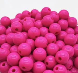 Detail shot of glossy pink acrylic round beads with straight holes, perfect for DIY jewelry craft.