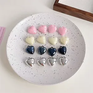 Close-up of glossy heart-shaped charms, colorful DIY pendant accessories for keychains.
