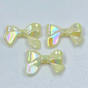 Close-up detail of iridescent acrylic bow charms, macaron color DIY jewelry making beads.