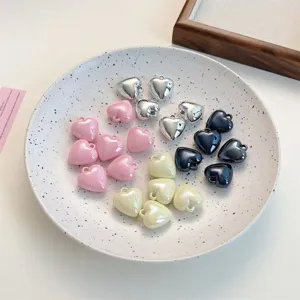 Close-up detail of glossy heart-shaped charms in various colors for DIY handmade jewelry crafting.