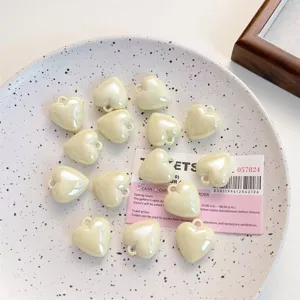 Detail display of DIY creamy white heart charms, ideal for handmade keychain and jewelry making.