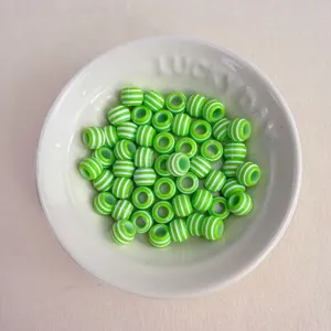 Grün-weiße gestreifte Acryl-Perlen im Detail, ideal für DIY-Schmuckherstellung und Zubehör.