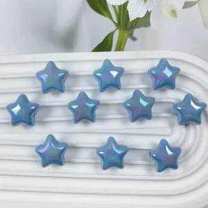 Close-up detail shot of glossy iridescent blue star beads on a white tray for DIY.
