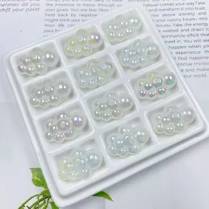 Primo piano di perline nuvola in acrilico iridescenti con foro per creazione di gioielli.