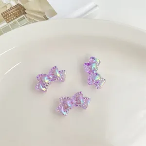 Primer plano de abalorios acrílicos con lazo morado iridiscente para detalles de joyería DIY.