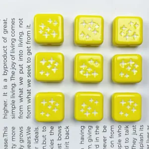 Primo piano di perline quadrate in acrilico giallo con motivi a stella bianca per gioielli fai-da-te.