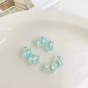 Detalle de cerca de dijes de lazo acrílico iridiscente, accesorios de joyería de arcoíris brillante.