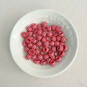 Nahaufnahme von 5mm rot-weißen Acryl-Abstandshalterperlen in einer weißen Schale für DIY-Schmuck.