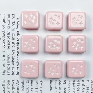 Primo piano di perline quadrate in acrilico rosa, ideali per ciondoli e gioielli fai da te.