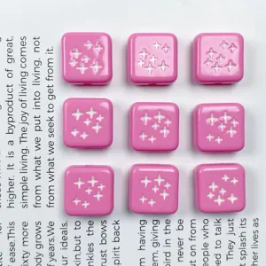 Primo piano di perline acriliche quadrate rosa con motivi a stella per creazioni fai da te.