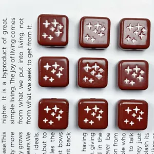 Dettaglio perline quadrate in acrilico, motivo stella laccato per accessori fai da te.
