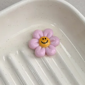 Pink smiley flower resin charm bead for DIY jewelry making, crafts and hair accessories.