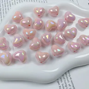 Close-up of pink AB iridescent heart acrylic beads for DIY jewelry making and crafts.