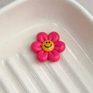 Close-up detail of a vibrant pink resin smiley flower charm for DIY jewelry making supplies.