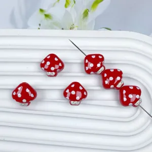 Primo piano di perline a fungo rosse da 17 mm a pois per creazione di gioielli fai-da-te.