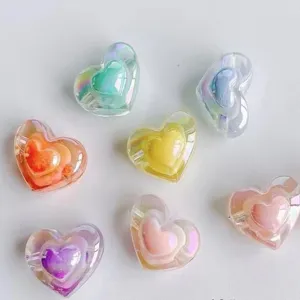 Close up of colorful acrylic AB plated 3D heart beads, transparent DIY jewelry accessory details.