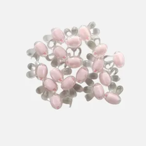 Dettagli in primo piano di perline acriliche rosa a forma di orecchie di coniglio per gioielli.