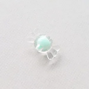 Detalle en primer plano de cuenta de caramelo de acrílico transparente con esfera verde.